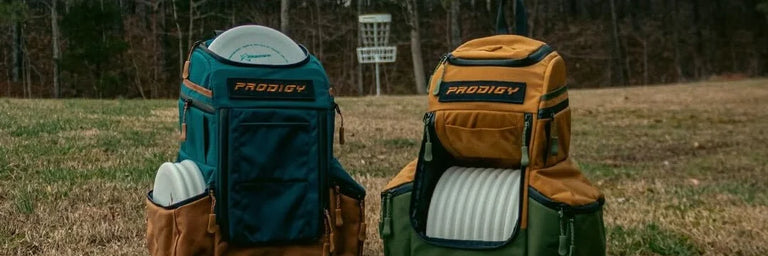 To Prodigy tasker fyldt med hvide discs der står foran en kurv på en græsplæne